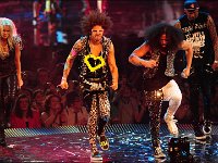 LMFAO  SkyBlu in performance wearing a mismatched pair of black and white high top chucks.
